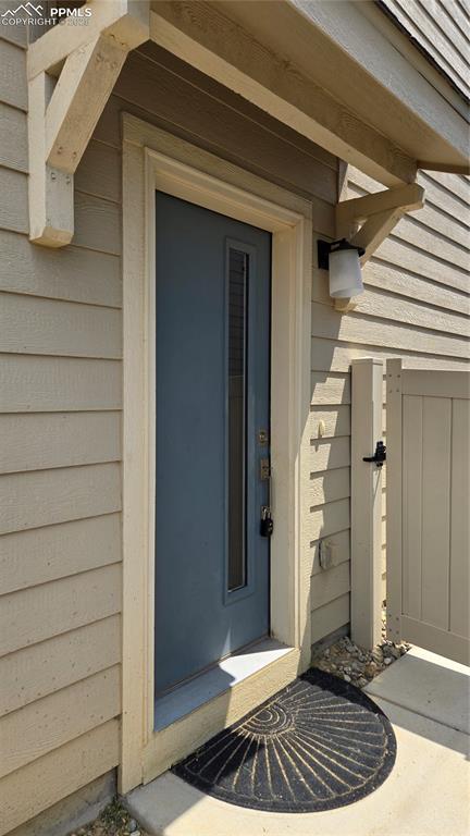 Image 2 of 29: Property entrance on left side of home behind fence.