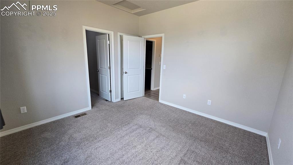 Image 24 of 29: Unfurnished bedroom featuring carpet and access to bathroom. 