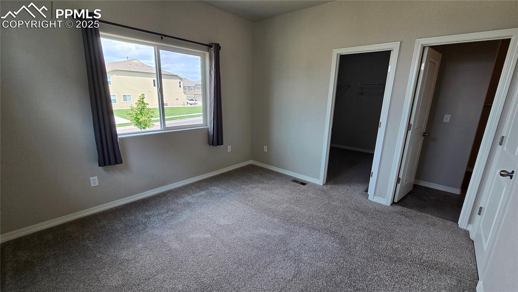Image 25 of 29: Unfurnished bedroom with carpet flooring and a spacious walk-in closet