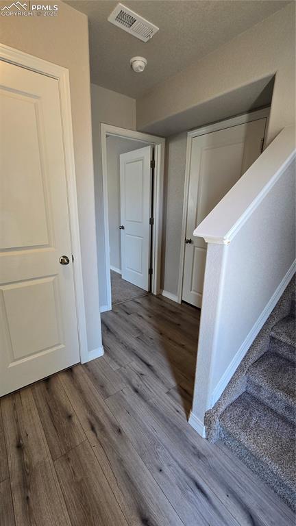 Image 4 of 29: Hallway featuring closet, door to garage, stairs to upper level and door to