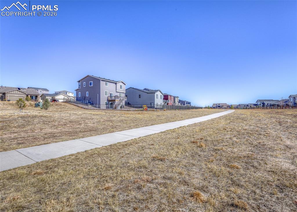 Image 48 of 50: walking trail and open space directly behind the home with no neighbors to