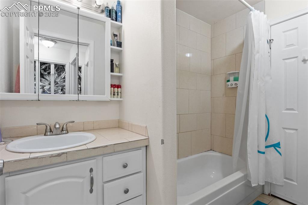 Image 16 of 21: Full bath with shower / bath combination with curtain and vanity