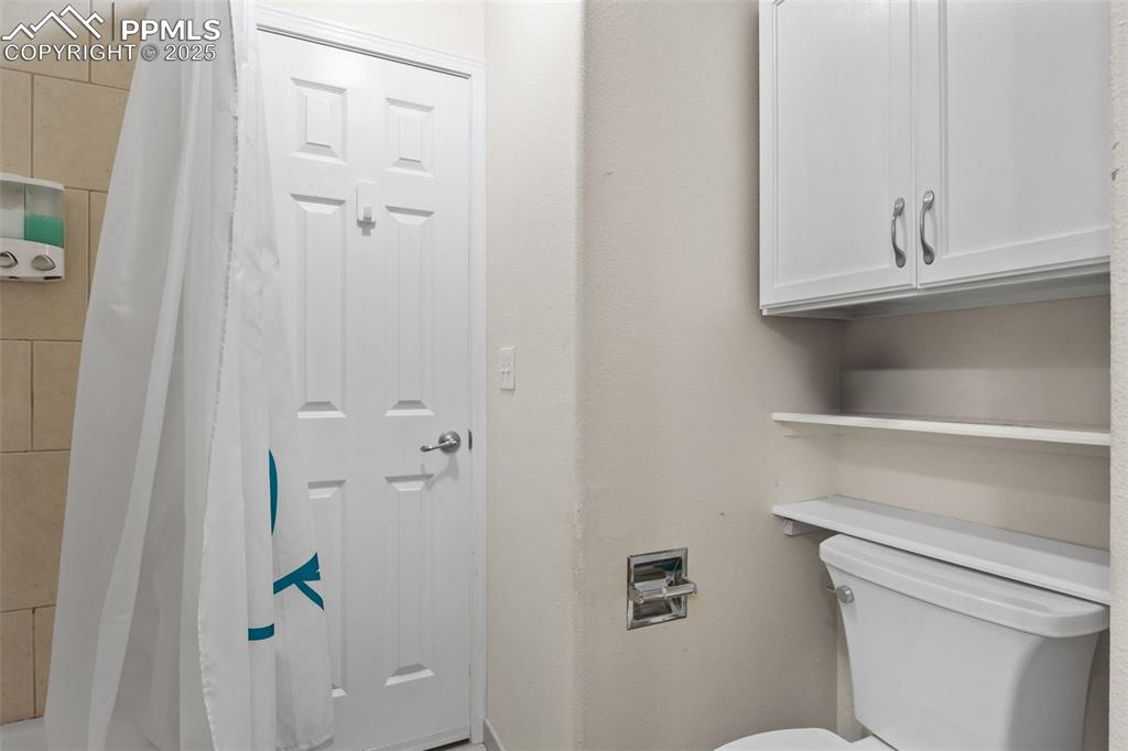 Image 17 of 21: Full bath with toilet and curtained shower