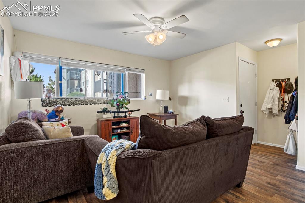 Image 4 of 21: Living room featuring ceiling fan and dark wood-style floors
