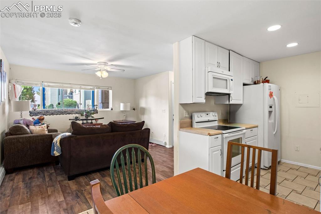 Image 8 of 21: Kitchen featuring white appliances, open floor plan, ceiling fan, white cab