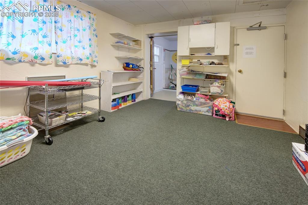 Image 12 of 34: Recreation room featuring dark colored carpet