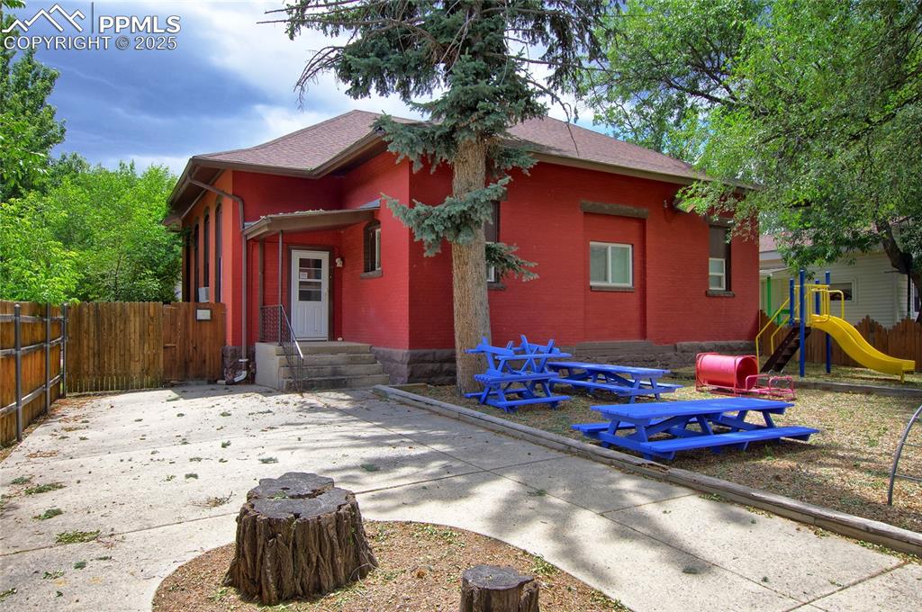 Image 31 of 34: View of front facade featuring a playground and brick siding
