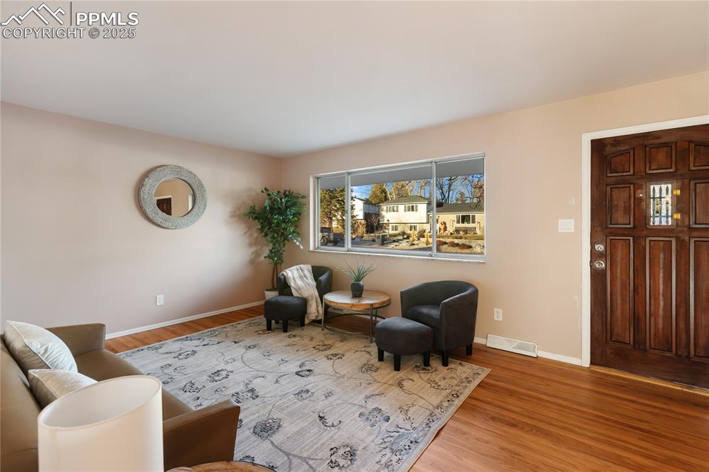 Image 10 of 38: Main level living room features a large picture window and recently refinis