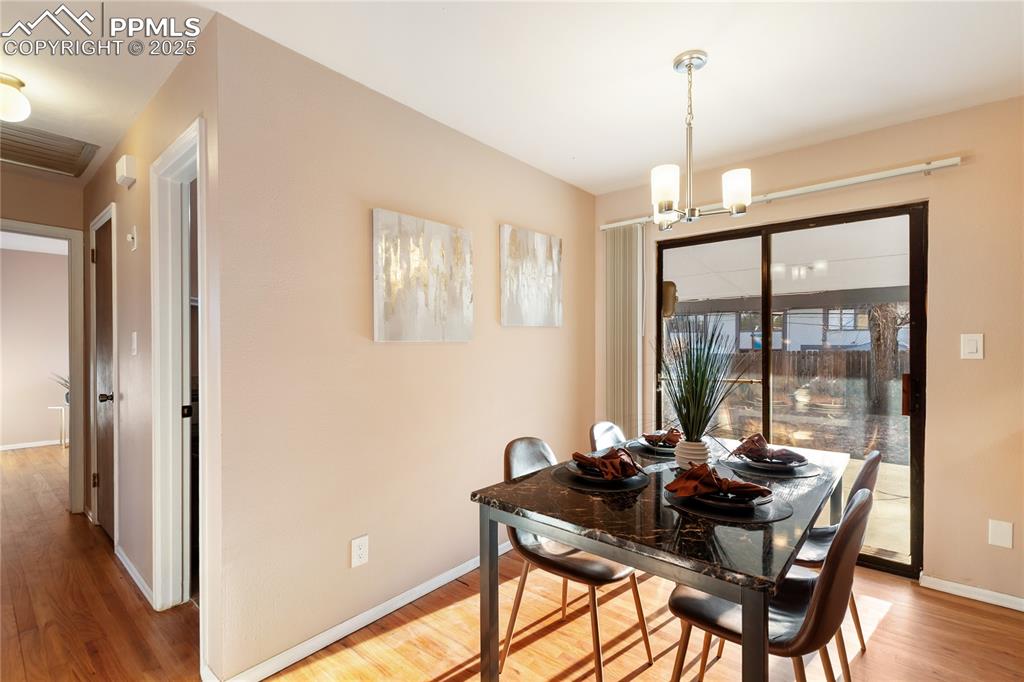 Image 13 of 38: Eat-in kitchen features recently refinished hardwood flooring, fresh paint