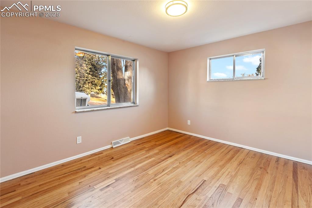 Image 23 of 38: One of 3 bedrooms on the main level - refinished hardwood flooring