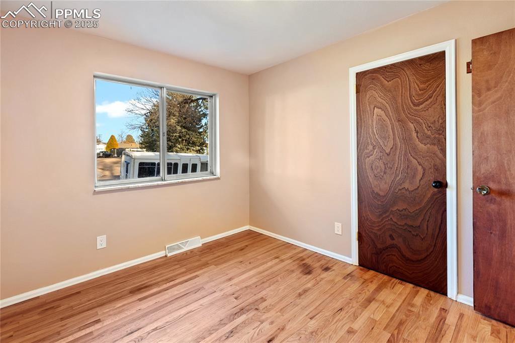 Image 25 of 38: One of 3 bedrooms on the main level - refinished hardwood flooring