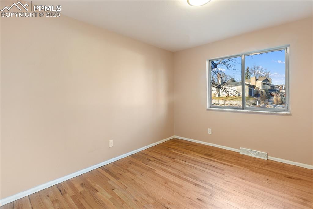 Image 26 of 38: One of 3 bedrooms on the main level - refinished hardwood flooring