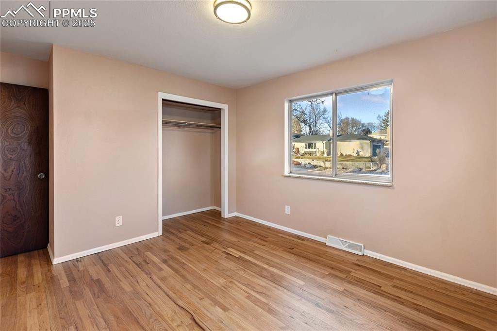 Image 27 of 38: One of 3 bedrooms on the main level - refinished hardwood flooring