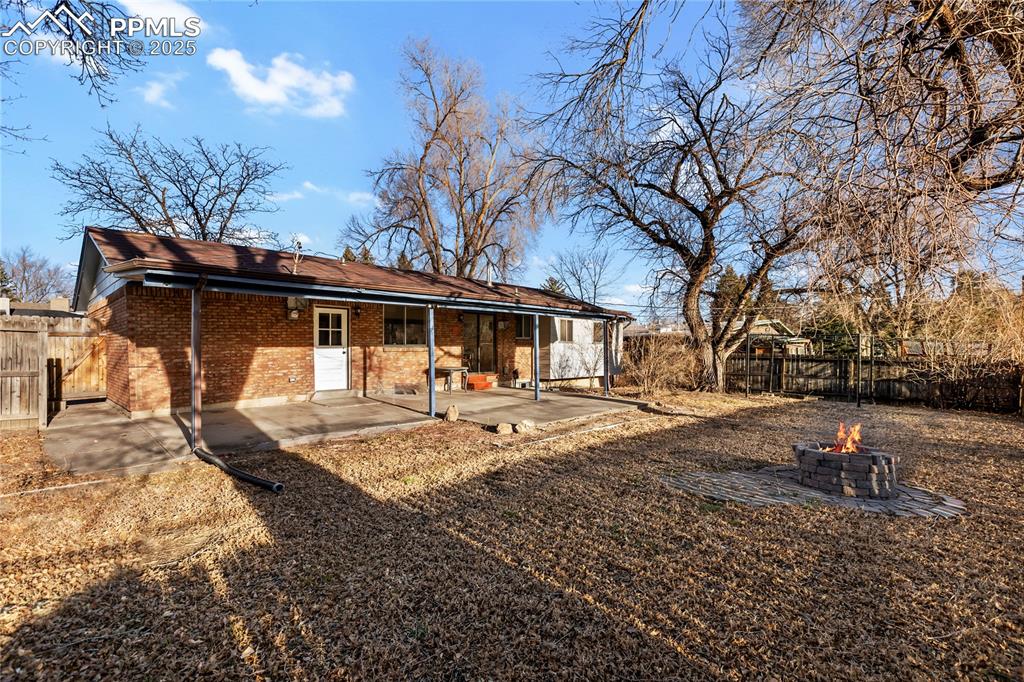 Image 5 of 38: Large, fenced yard complete with a fire pit. Large covered back patio.