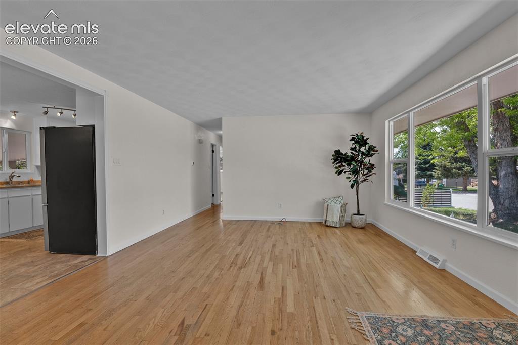 Image 7 of 40: Fresh paint, large updated windows and original hardwood floors greet you a