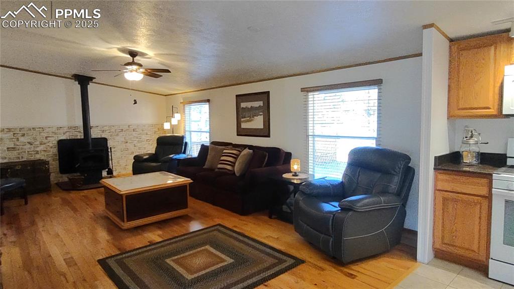 Image 10 of 42: Oak floors, windows with blinds, ceiling fan, and room for plenty of furnit