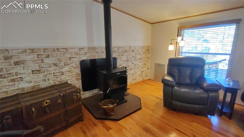 Image 12 of 42: Toasty wood stove for those chilly winter days. Newer brick-look half wall 