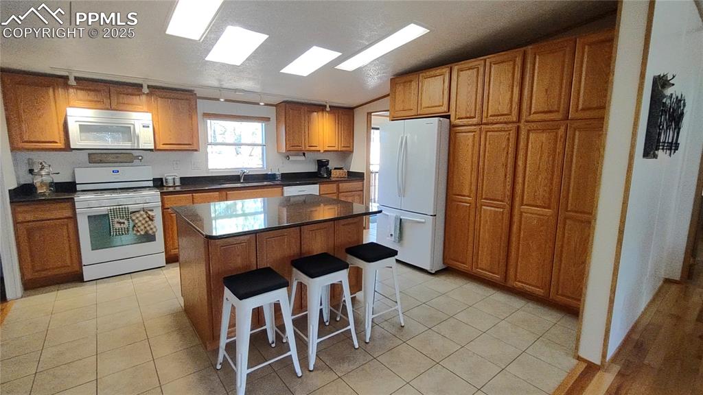 Image 13 of 42: Custom cabinetry provides oodles of storage. Breakfast bar offers convenien