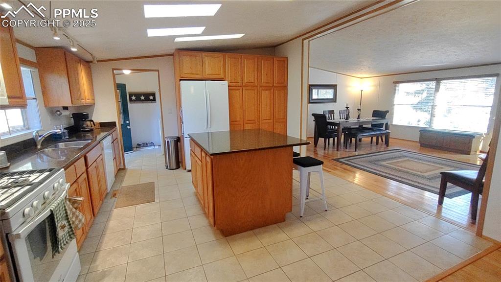 Image 14 of 42: Quartz countertops, skylights, & ceramic tile flooring in kitchen which ope
