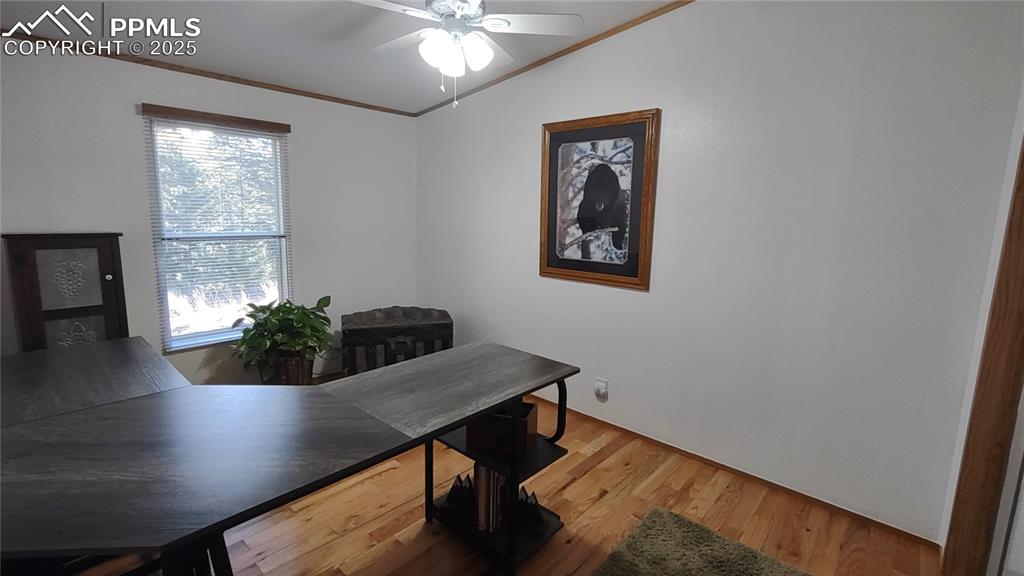 Image 23 of 42: Guest bedroom with ceiling fan also doubles as office.