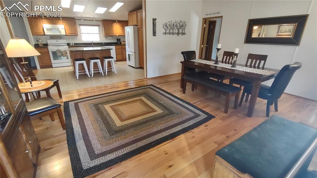 Image 7 of 42: Oak flooring and newer paint in living/dining room.