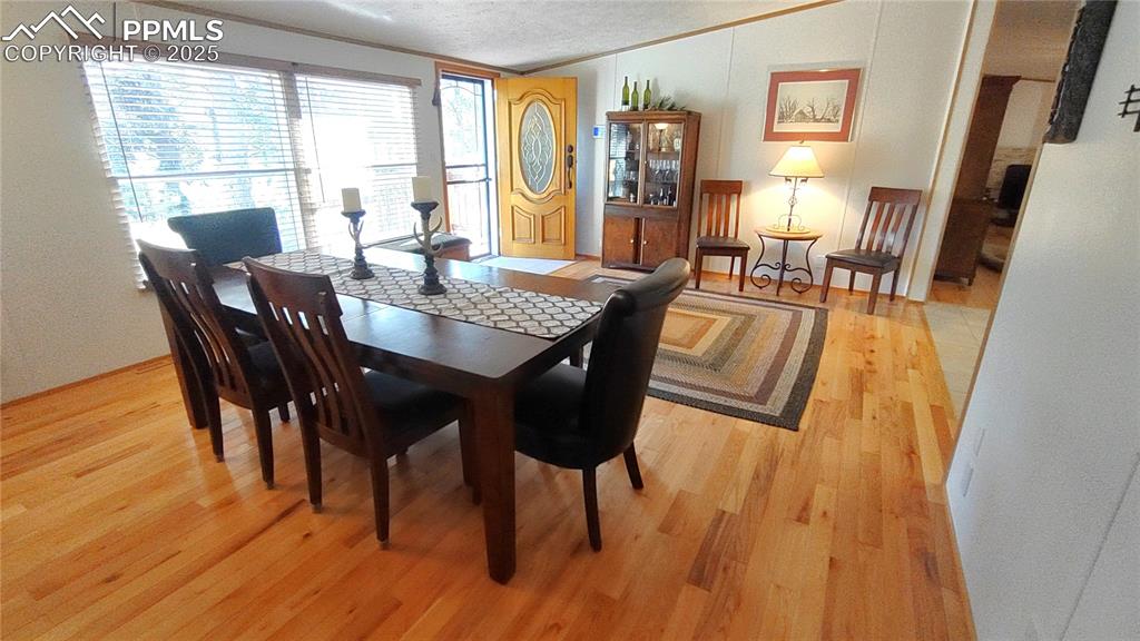 Image 8 of 42: Living/dining room has large windows to admire nature and blinds for privac