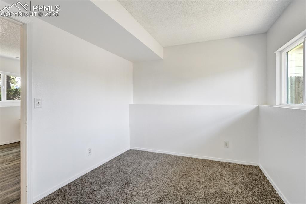 Image 24 of 33: Unfurnished room with a textured ceiling and carpet floors