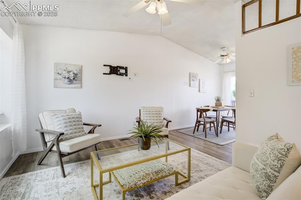 Image 6 of 33: Living room featuring a ceiling fan, vaulted ceiling, and wood finished flo