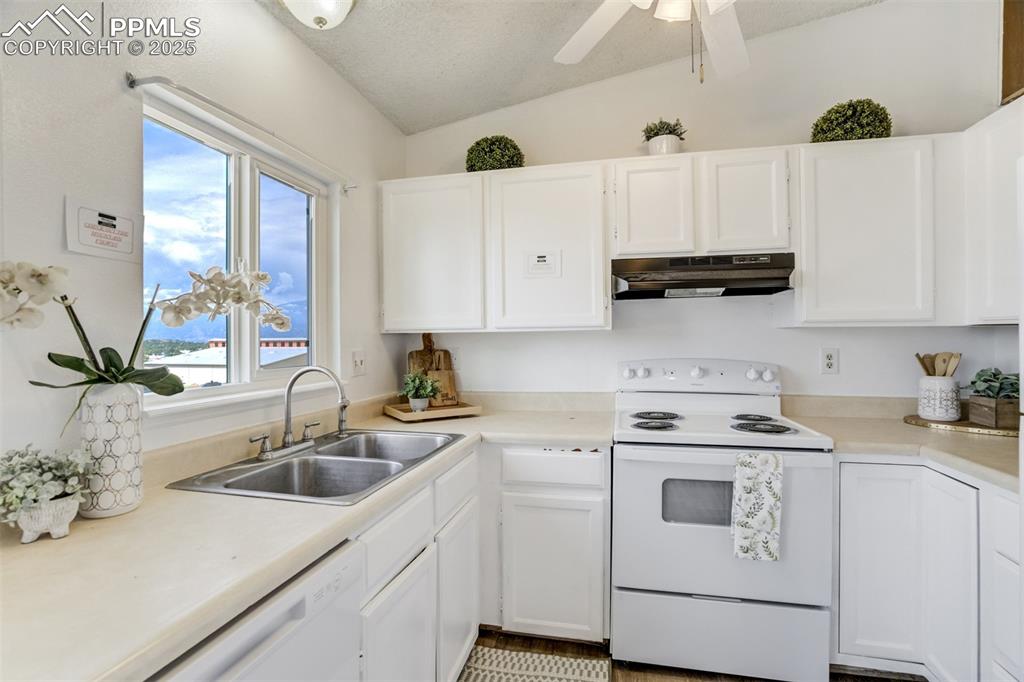 Image 9 of 33: Kitchen featuring white appliances, white cabinets, a textured ceiling, und