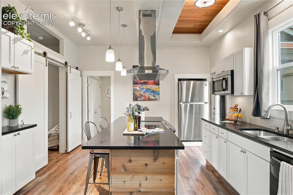 Image 7 of 50: Well equipped kitchen with large island, breakfast bar and coffered ceiling