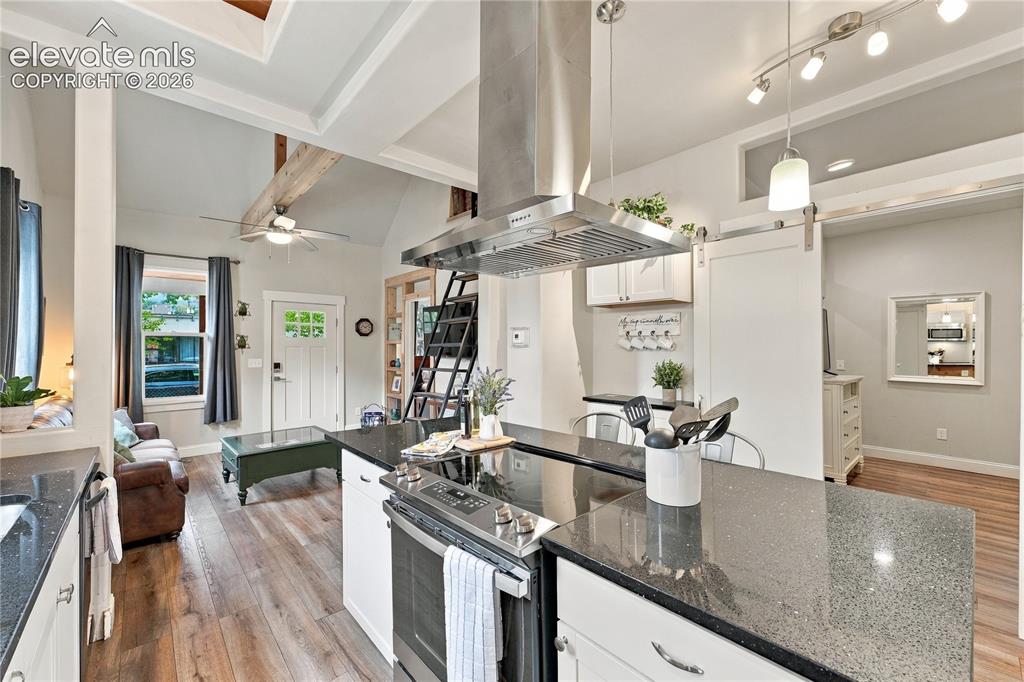 Image 9 of 50: Kitchen with large island, SS hood, secondary bedroom coffered ceilings. Se
