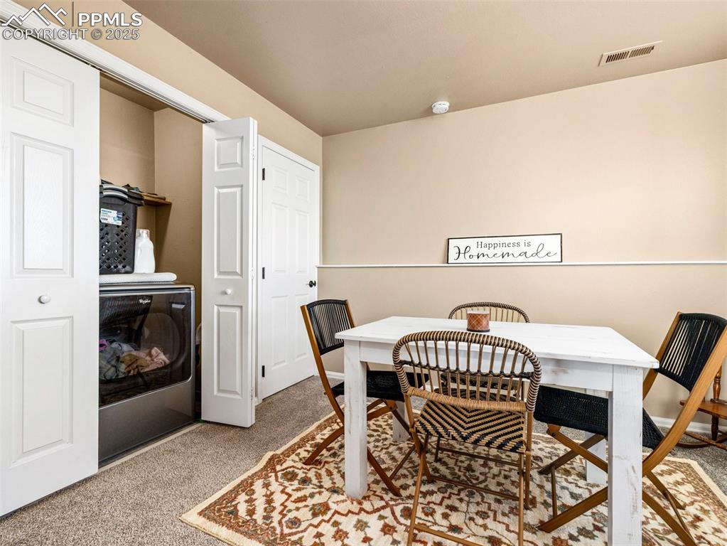 Image 17 of 41: Dining room with washer / dryer and light colored carpet