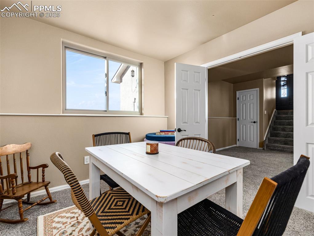 Image 18 of 41: Carpeted dining space with stairs and baseboards