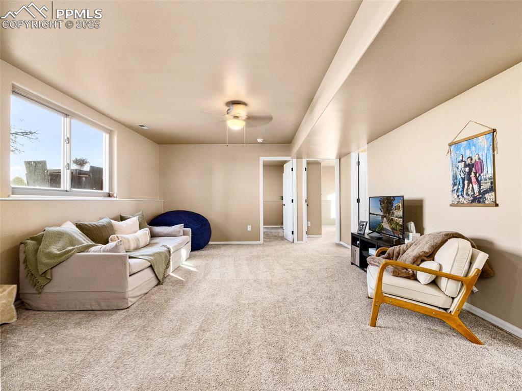 Image 19 of 41: Living room with carpet flooring and ceiling fan
