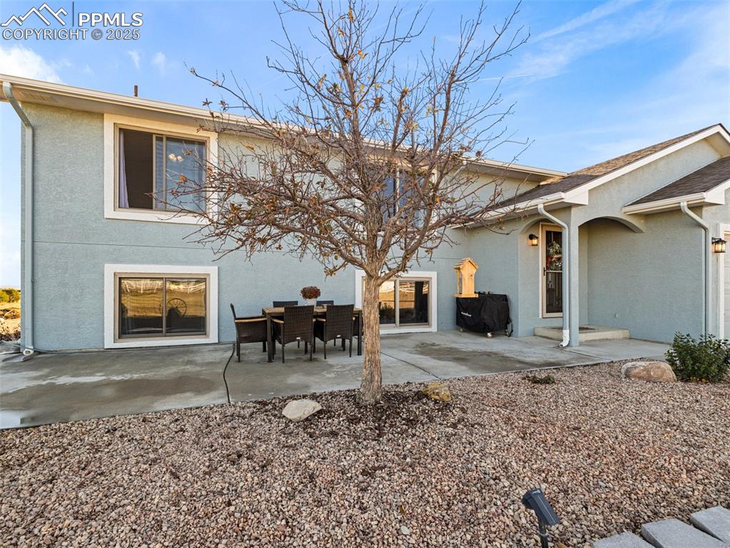 Image 2 of 41: Rear view of house featuring stucco siding and a patio