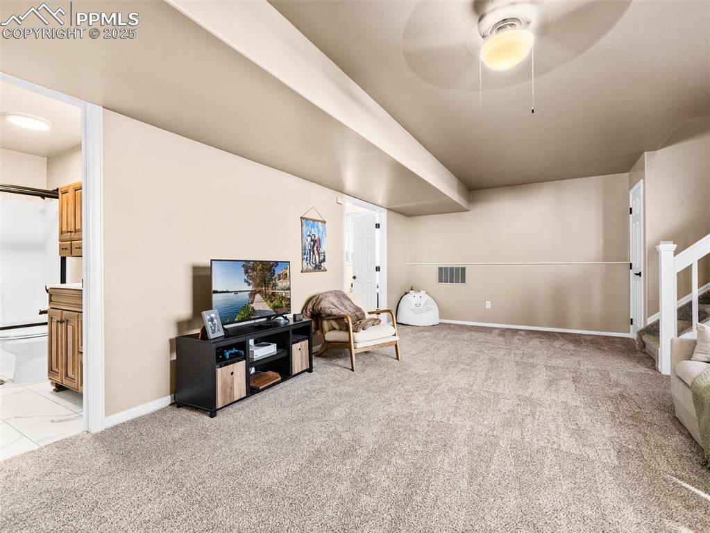 Image 20 of 41: Sitting room featuring stairway, light carpet, a barn door, and a ceiling f