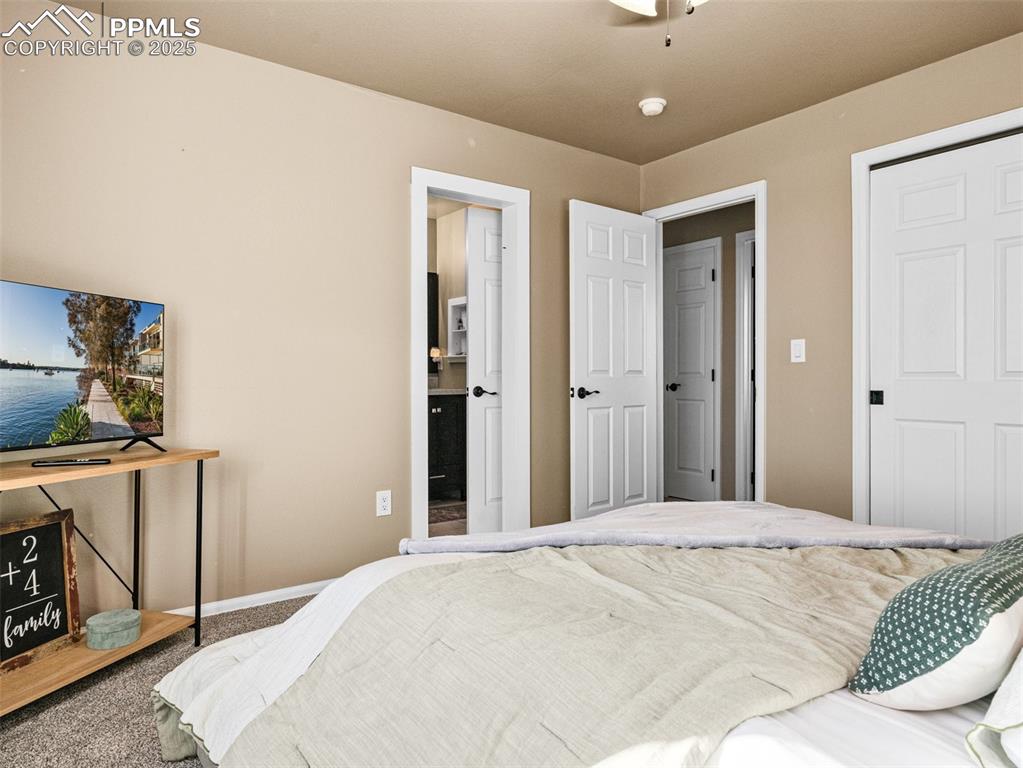 Image 22 of 41: Bedroom with carpet floors, a ceiling fan, a closet, and connected bathroom