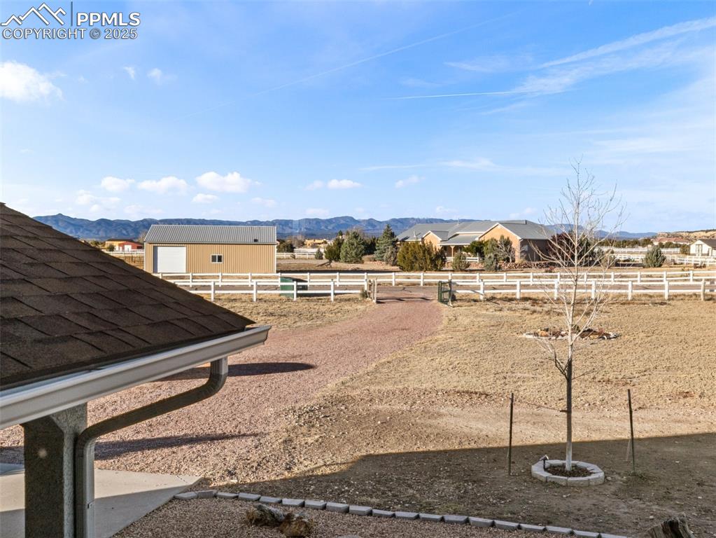 Image 31 of 41: View of yard with an outdoor riding arena and a mountain view