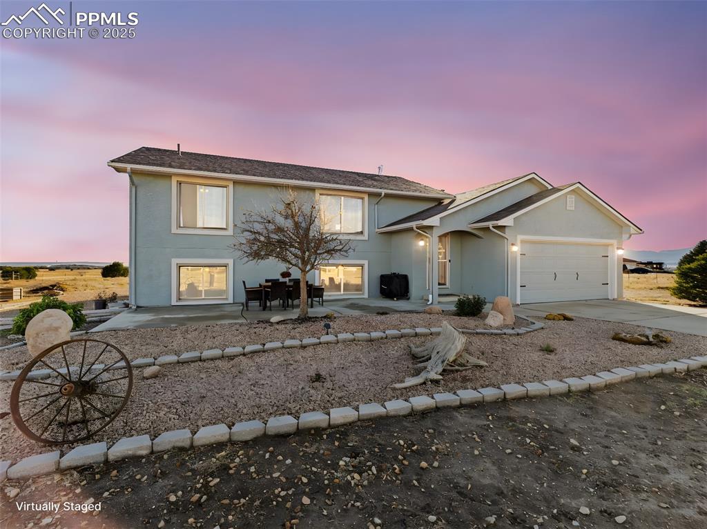 Image 7 of 41: View of front of house with stucco siding, concrete driveway, a garage, and