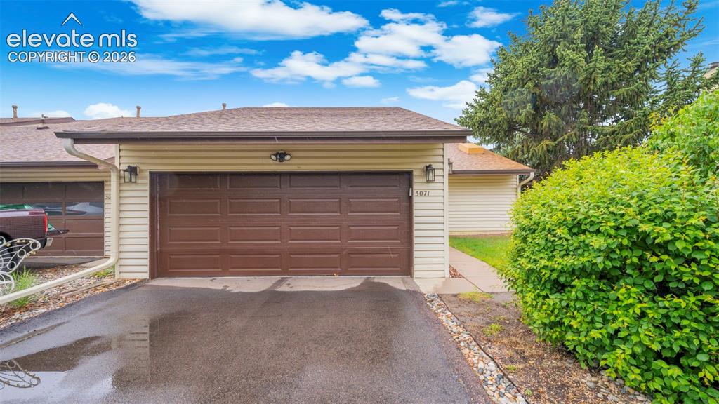 Image 1 of 37: Beige horizontal siding exterior with a brown sectional garage door, asphal
