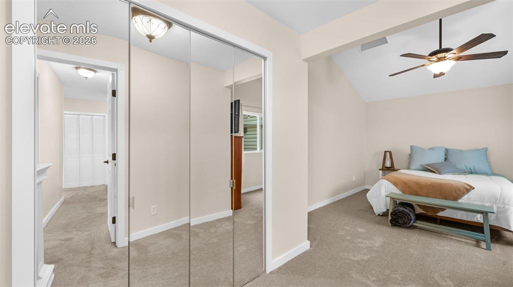 Image 11 of 37: Carpeted interior space featuring mirrored closet doors, a vaulted ceiling,