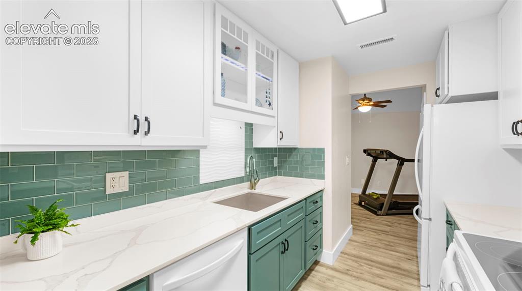 Image 19 of 37: Contemporary kitchen featuring white upper cabinetry, teal lower cabinetry,