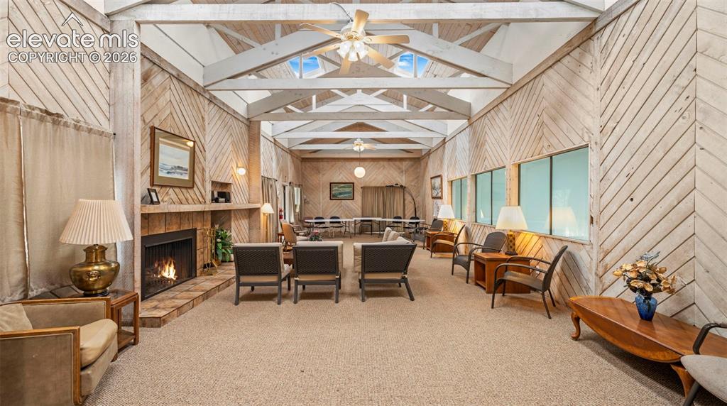 Image 31 of 37: Spacious gathering area featuring vaulted ceilings with exposed beams, skyl