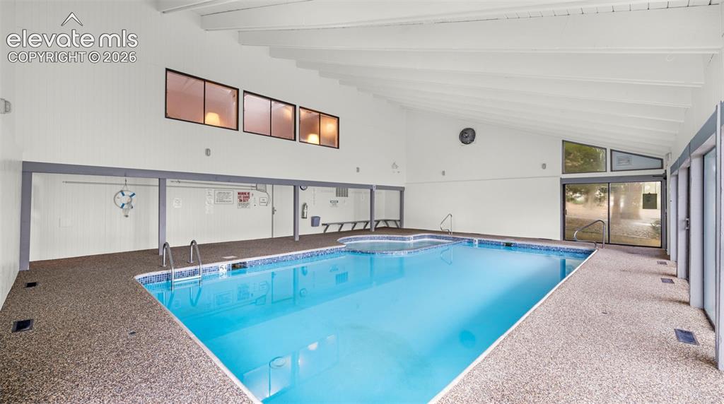 Image 33 of 37: Indoor swimming pool with an exposed beam vaulted ceiling