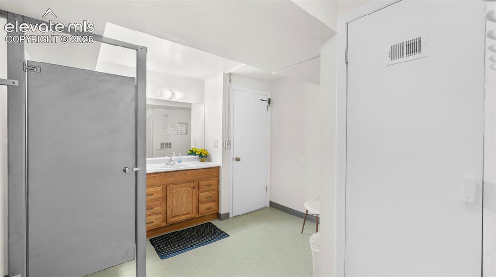 Image 35 of 37: Bathroom featuring a wood vanity with a white countertop and rectangular si