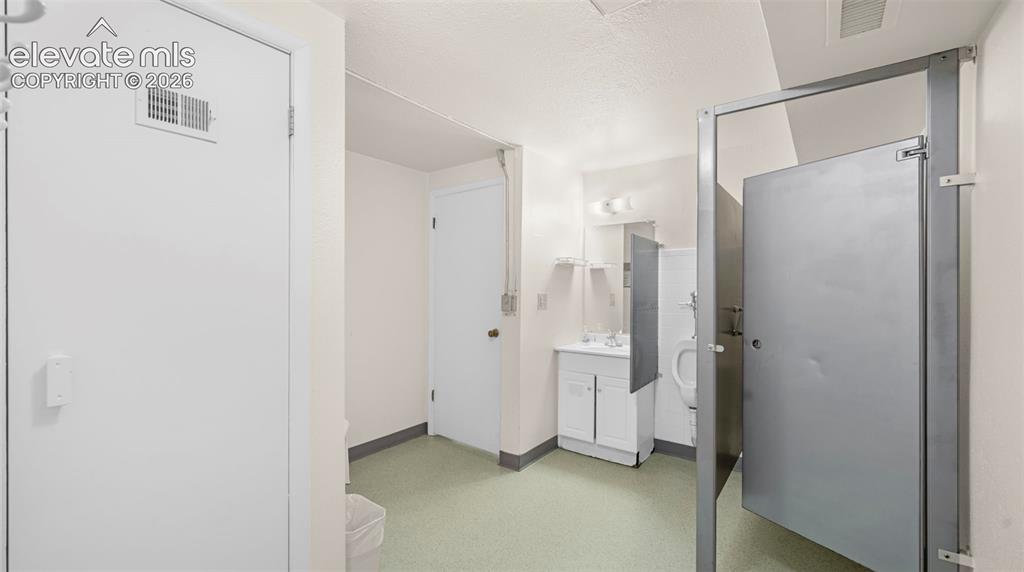 Image 36 of 37: Restroom area featuring light green flooring and white walls