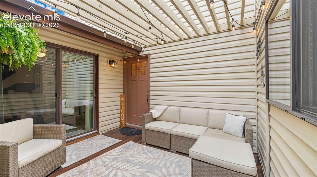 Image 4 of 37: Spacious outdoor patio with a slatted pergola, durable wood-finish flooring