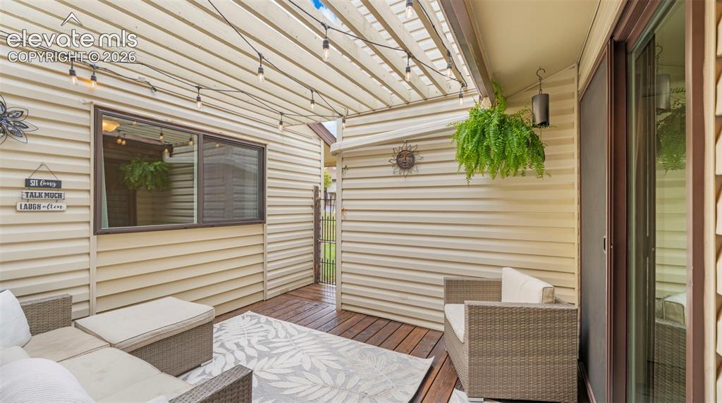 Image 5 of 37: Outdoor patio featuring wood-finish decking, light-colored siding, and a sl