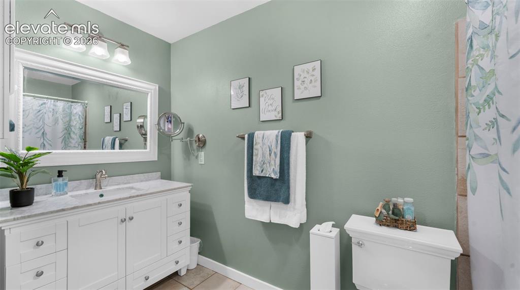 Image 6 of 37: Bathroom featuring a white vanity with an integrated sink, a light-toned co