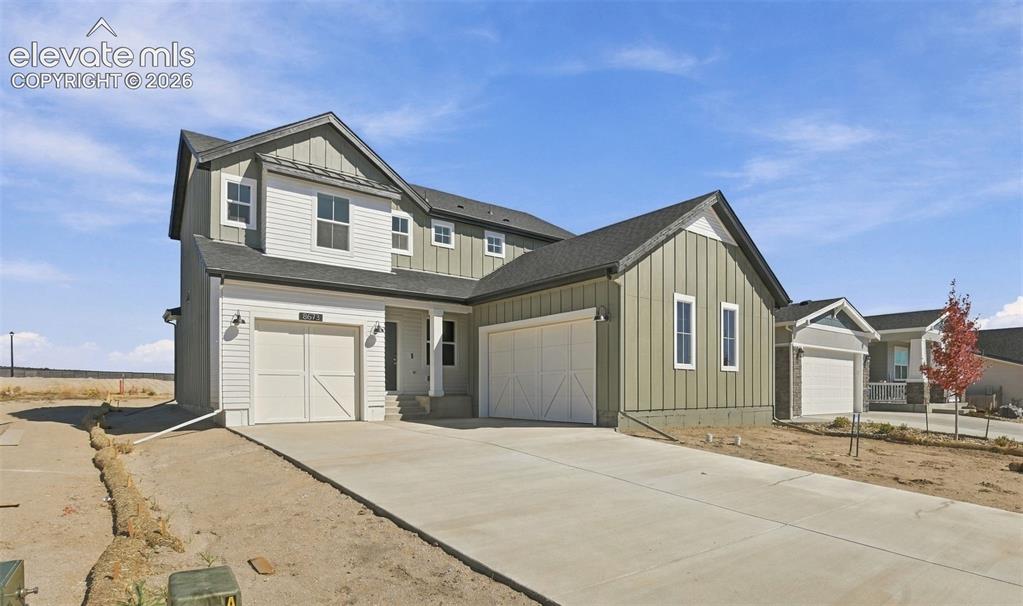 Caption: Two-story residence featuring vertical board-and-batten siding, a combination of horizontal lap sidi